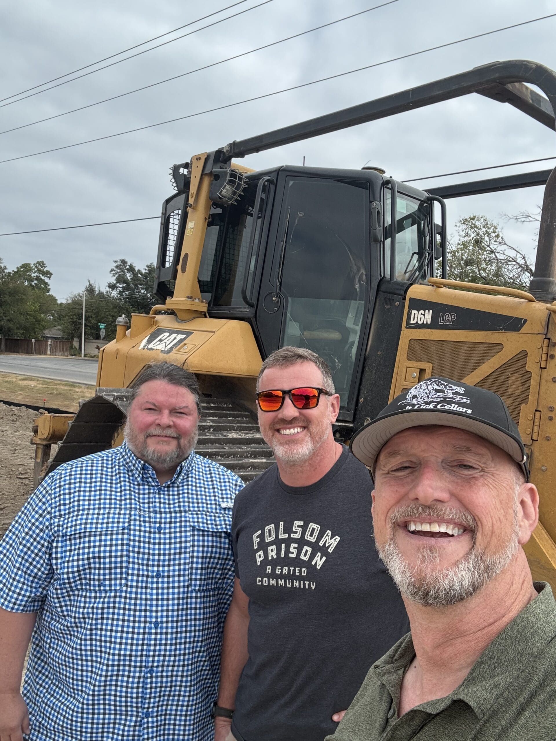 The three Buda Capital Partners founders standing together on the active Roundabout development site in Buda, Texas